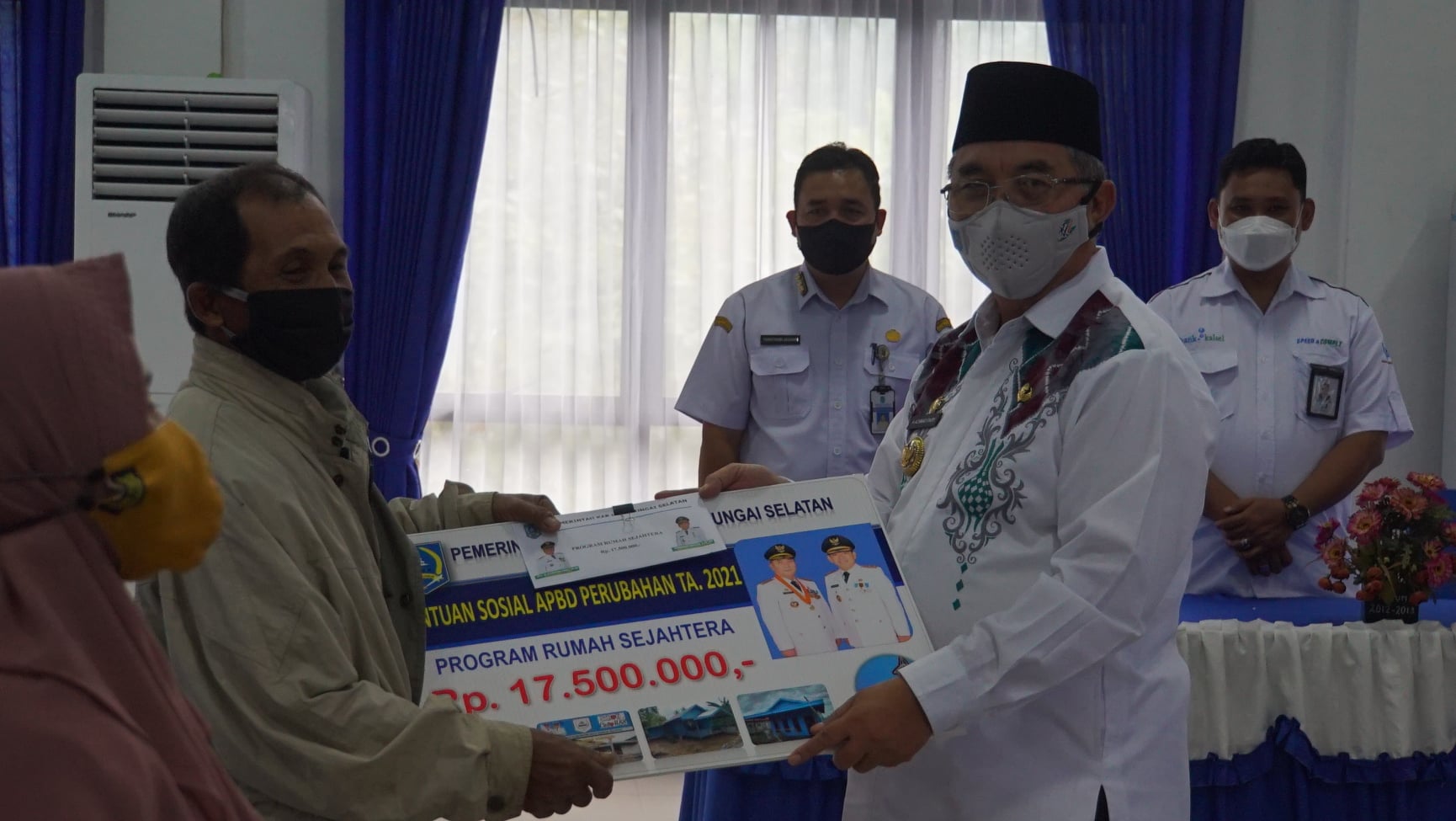Bupati Hulu Sungai Selatan menyerahkan secara simbolis bantuan Program Rumah Sejahtera (PRS) dan Usaha Ekonomi Produktif APBD perubahan tahun anggaran 2021 sekaligus memberikan arahan kepada Keluarga Penerima Manfaat (KPM) pada Kecamatan Kandangan dan Kecamatan Sungai Raya di Aula Kecamatan Kandangan